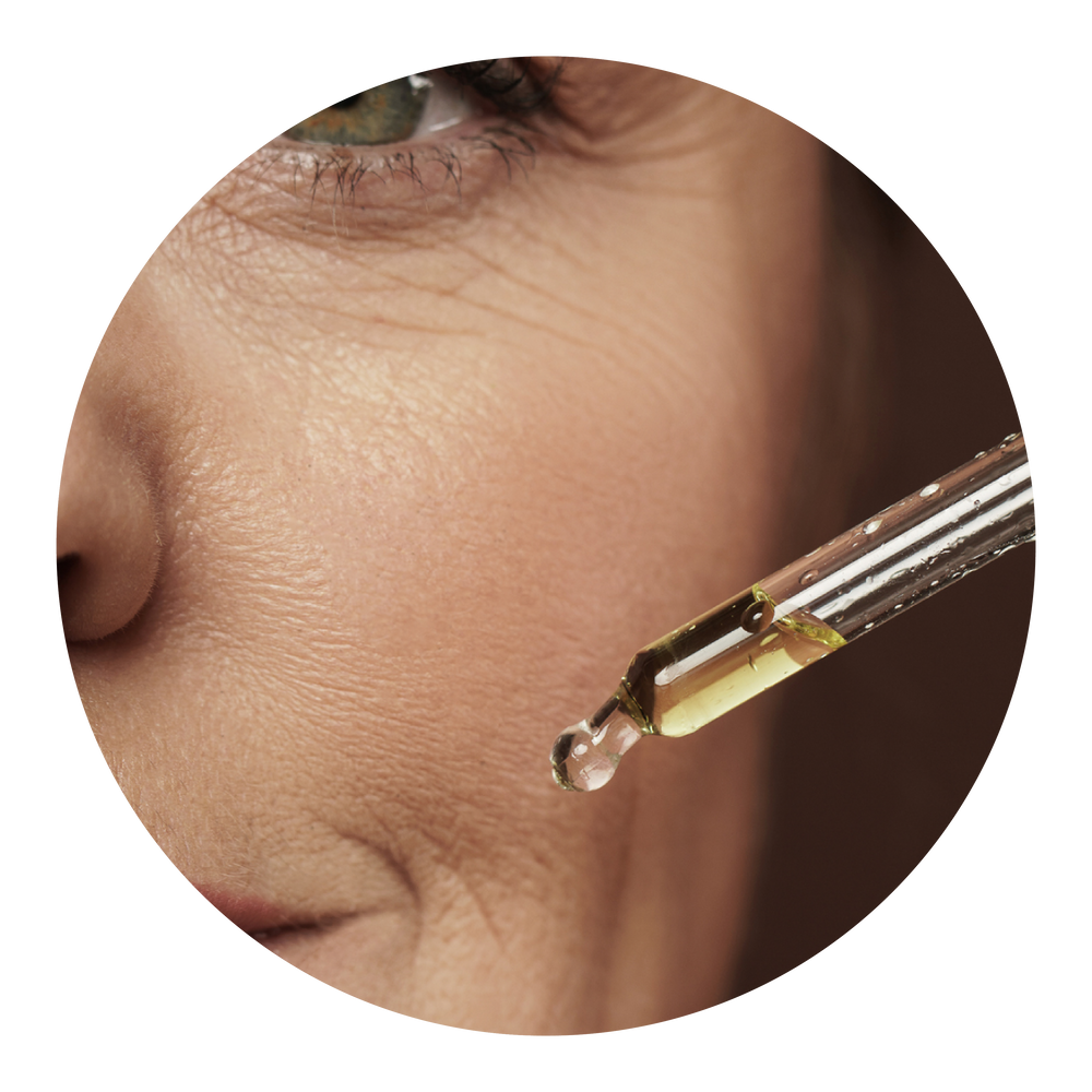 Serum dropper held against skin with visible pigmentation